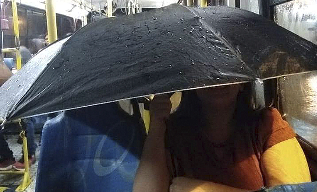 Passageira usa guarda-chuva em ônibus com goteiras durante a chuva em Rio Branco e ativista cobra prefeitura 