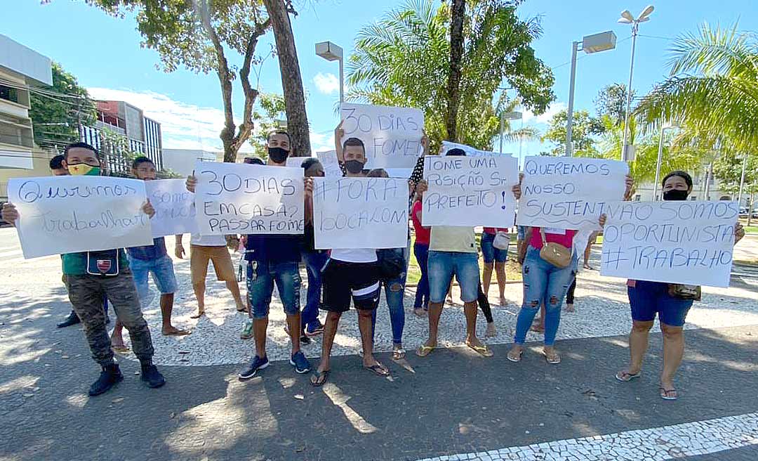 Com cartazes com as frases "queremos trabalhar" e "fora Bocalom", camelôs protestam no centro de Rio Branco