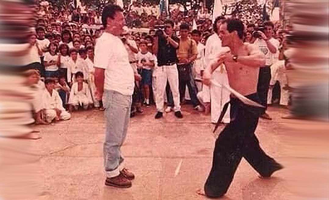 Página na internet mostra foto de apresentação feita por Mestre Juca ao governador Edmundo Pinto, cercados por uma multidão