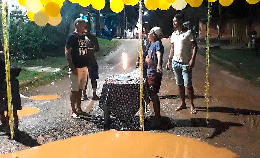 Em Epitaciolândia, moradores “comemoram” aniversário de buraco e manifestante pula em poça d'água