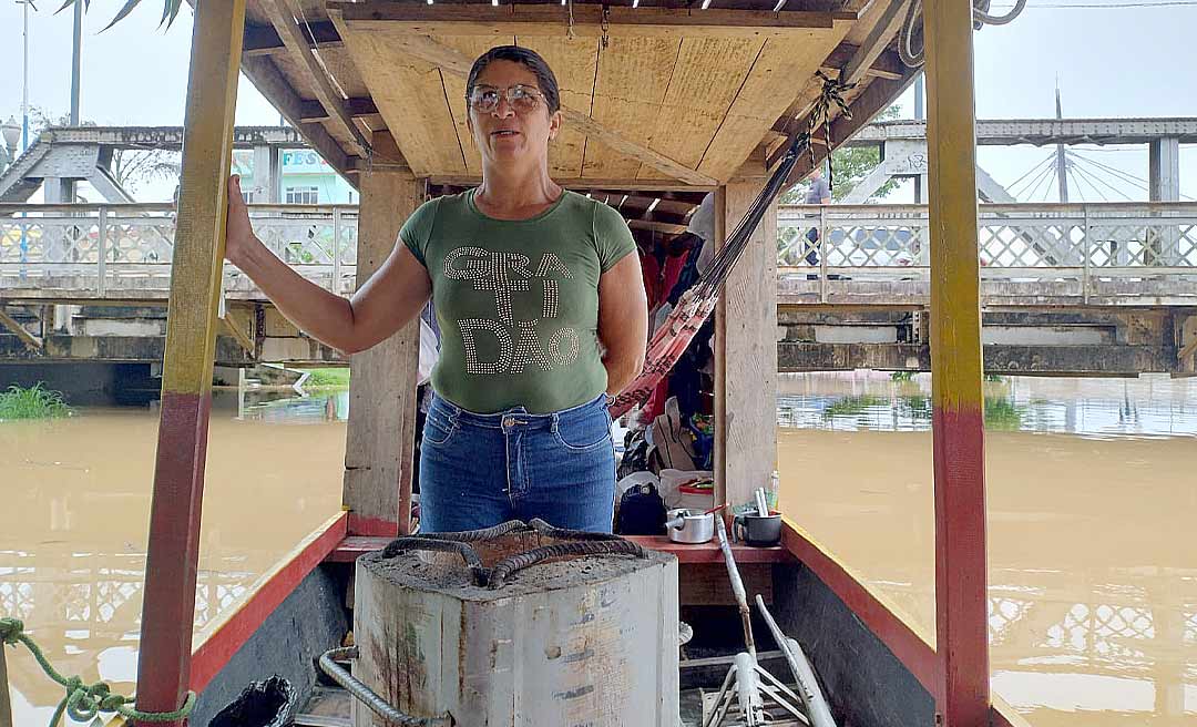 Afetado pela cheia na zona rural, casal dorme em batelão ao lado da Ponte Metálica à espera da vazante do rio