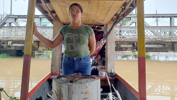 Afetado pela cheia na zona rural, casal dorme em batelão ao lado da Ponte Metálica à espera da vazante do rio