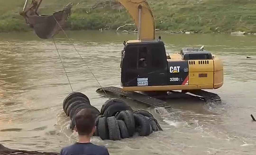 No primeiro dia de limpeza do rio Acre, retroescavadeira do Deracre retira imensa quantidade de pneus do manancial